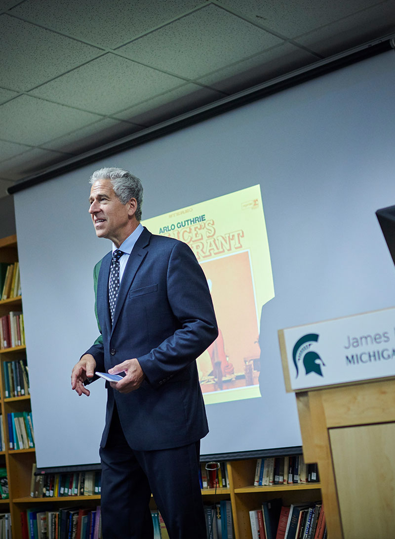 Eric Sirotkin Speaking in front of Screen at Michigan State University