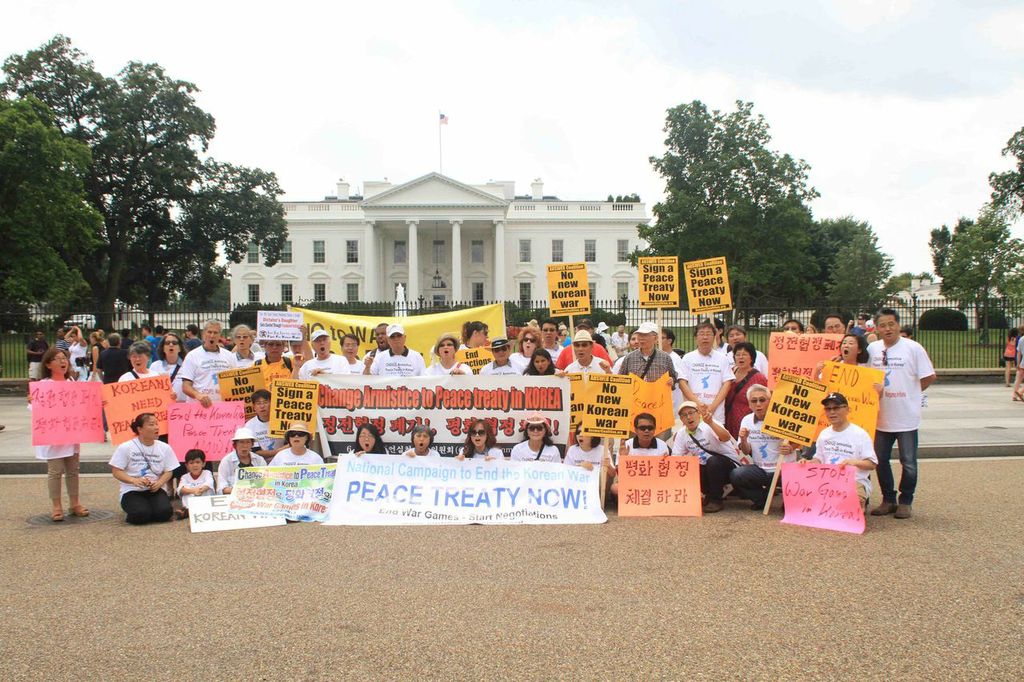 People holding signs for no war and peace in front of white house